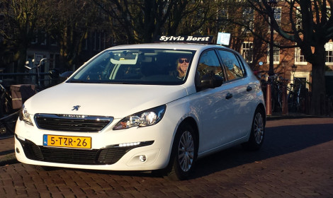 De lesauto van Sylvia Borst voor een Amsterdamse gracht